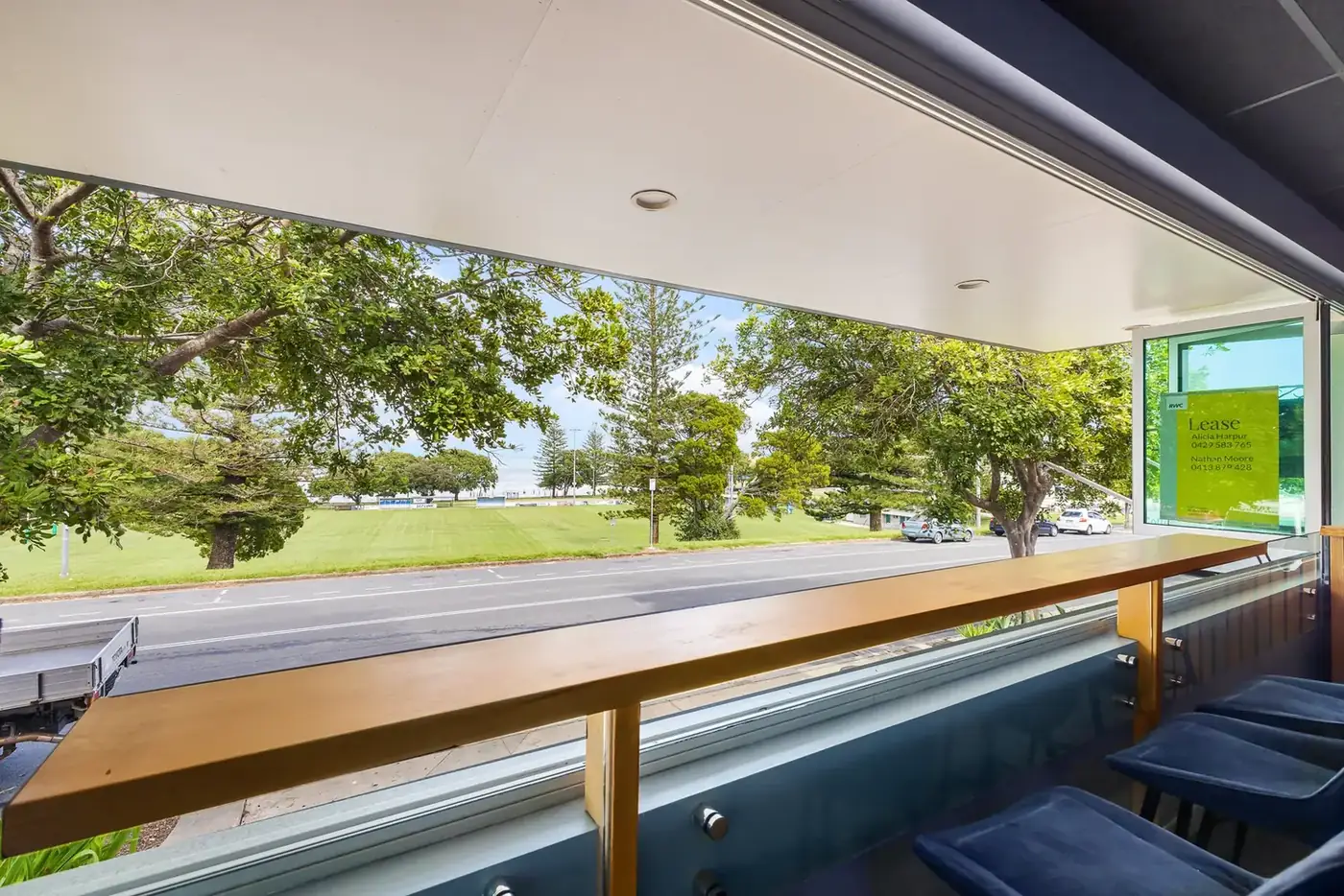 Supplied reference photo from inside looking out through the front windows toward the road and water beyond.